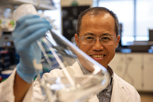 Image of researcher Mike Zhange with beaker