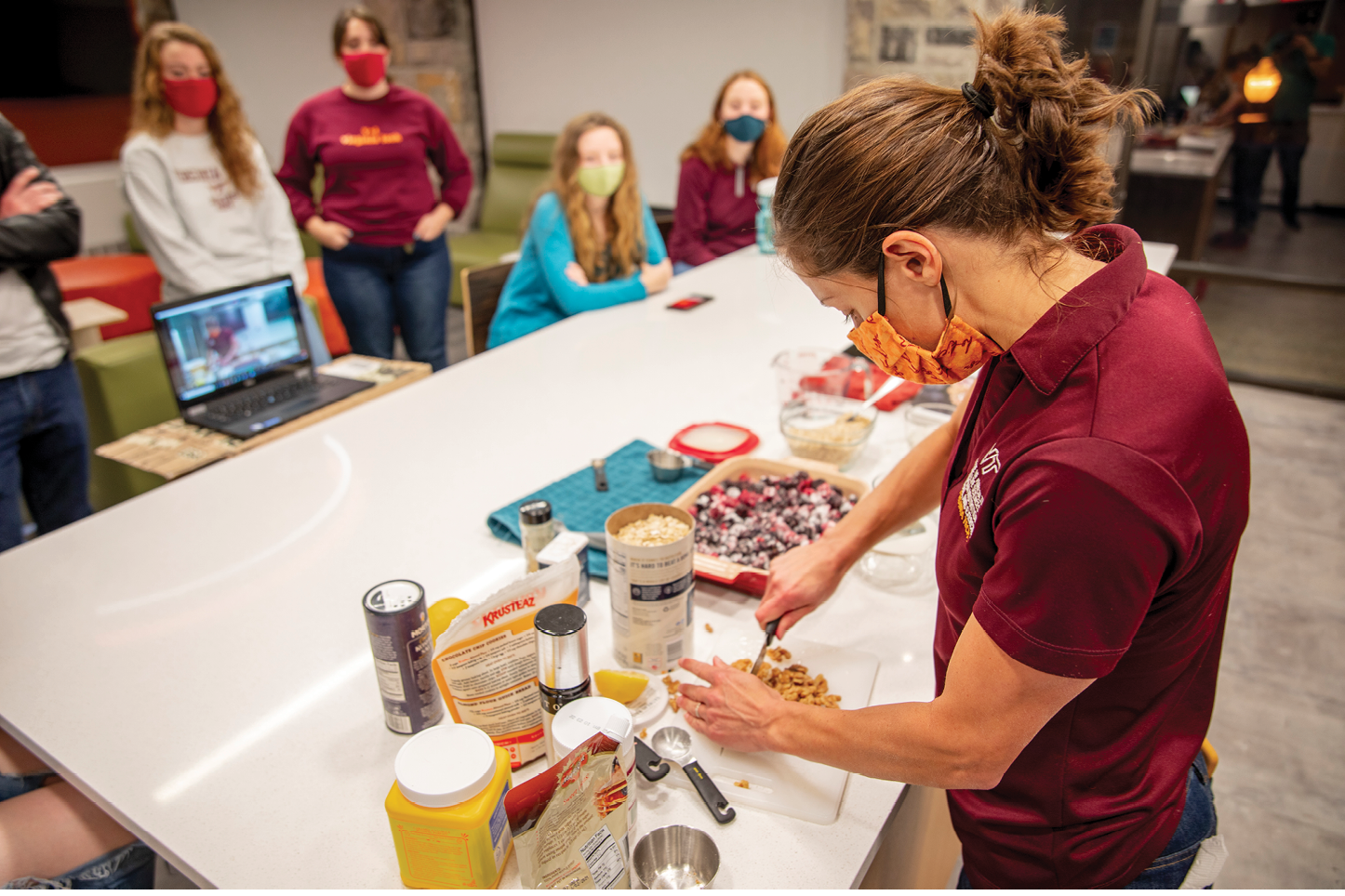 Image of Kristen Chang preparing food in front of students