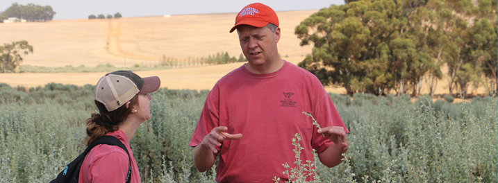 Image of Mark Reiter in discussion with a woman in a field