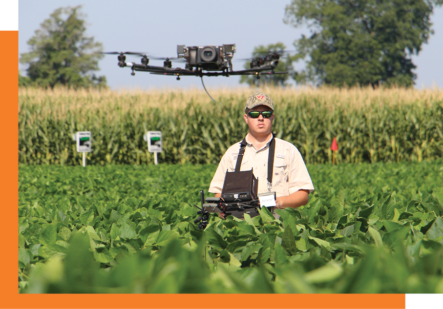 Image of a student in a field flying a drone